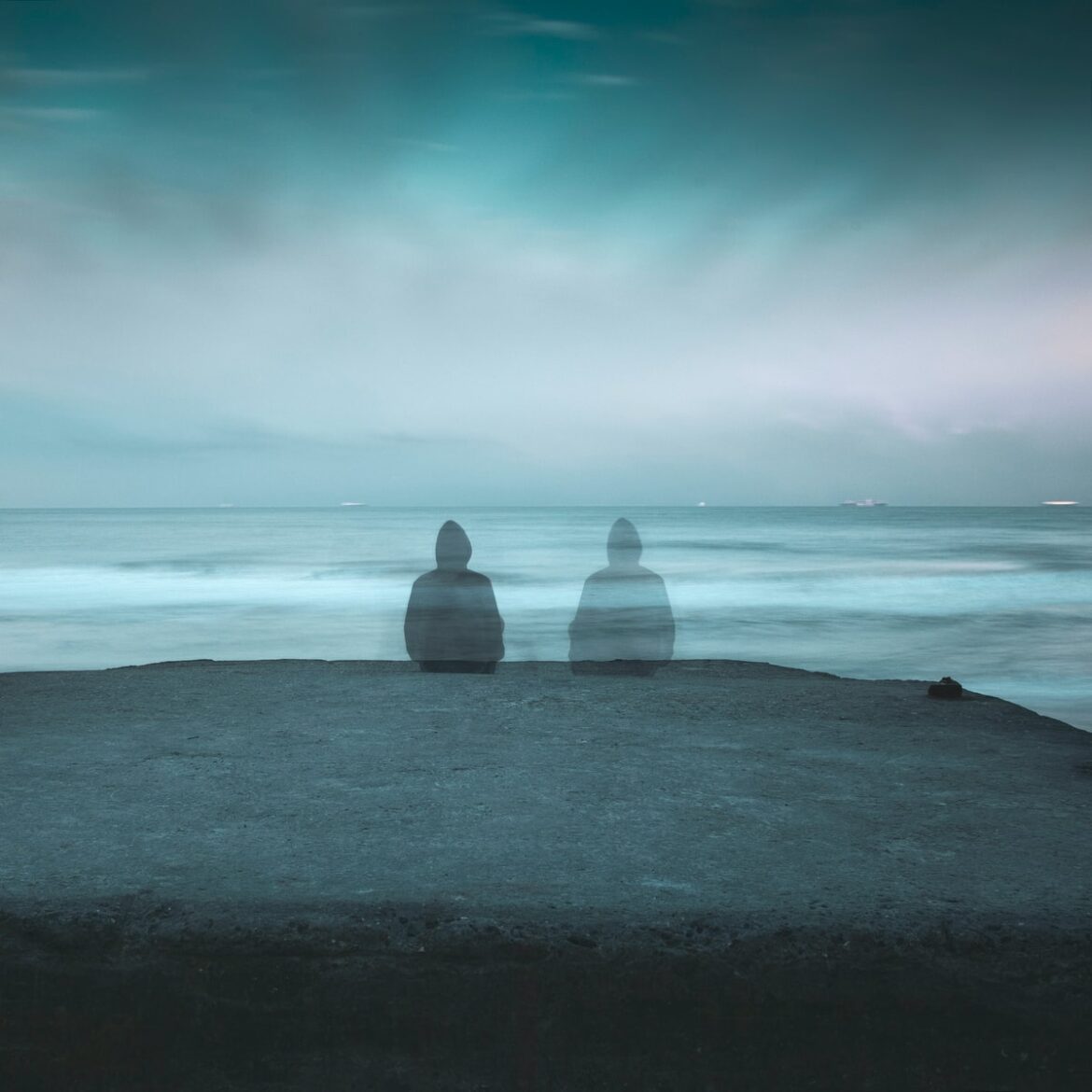 3 white and gray stone on black sand near body of water during daytime