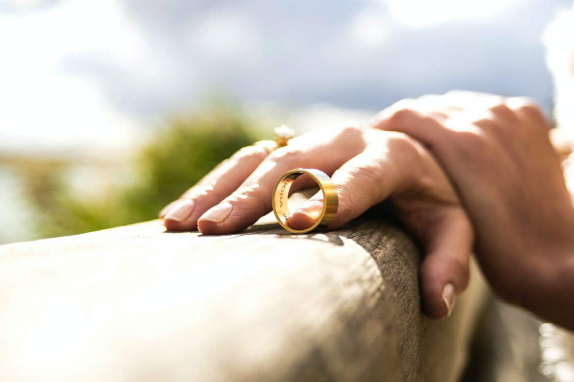 divorce person holding gold wedding band