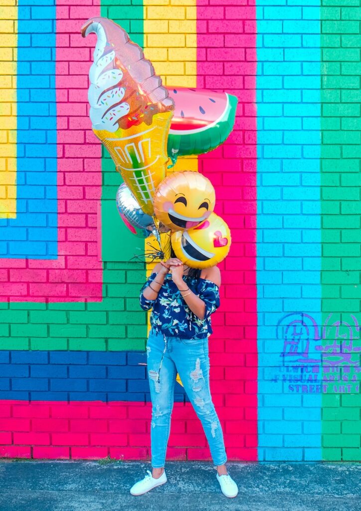 woman covering face with assorted ballons collegue désagréable