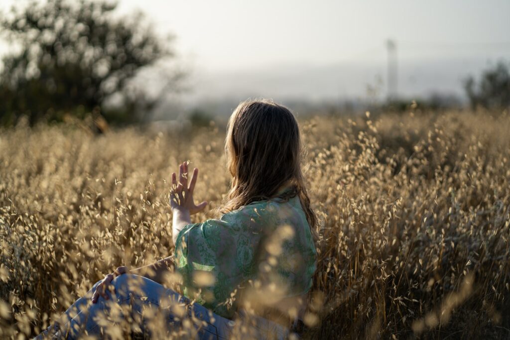 woman in blue and green floral dress standing on brown grass field during daytime. trouver du sens dans sa vie, je suis perdu quel est le sens d'une vie