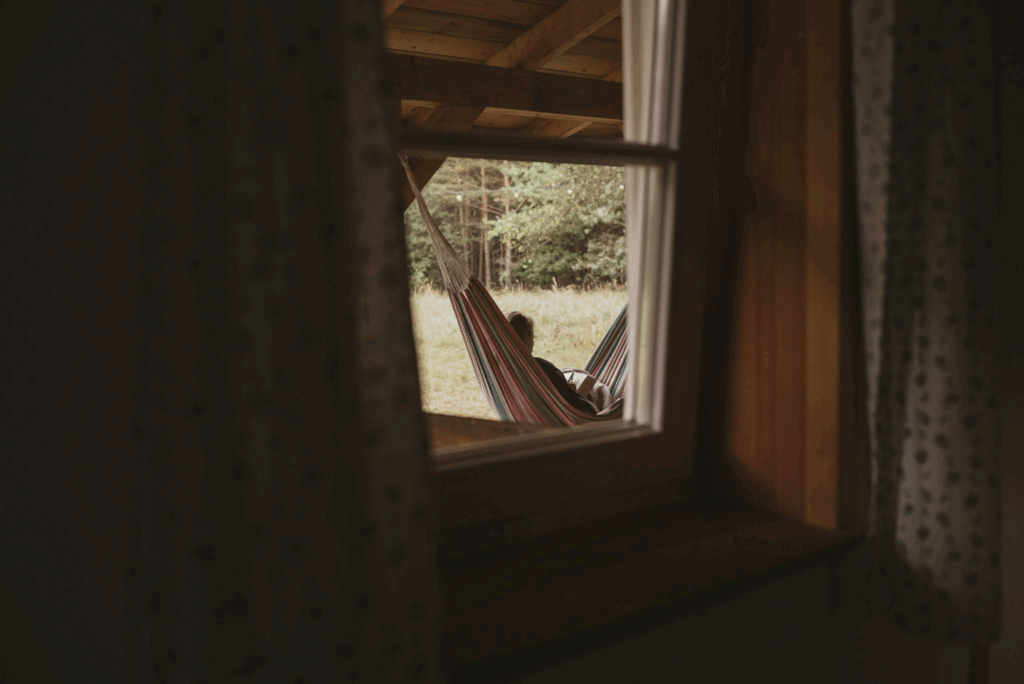 Gestion de la colère : guide complet pour apaiser ses réactions Photo d'une personne qui lit un livre dans son hamac devant sa maison