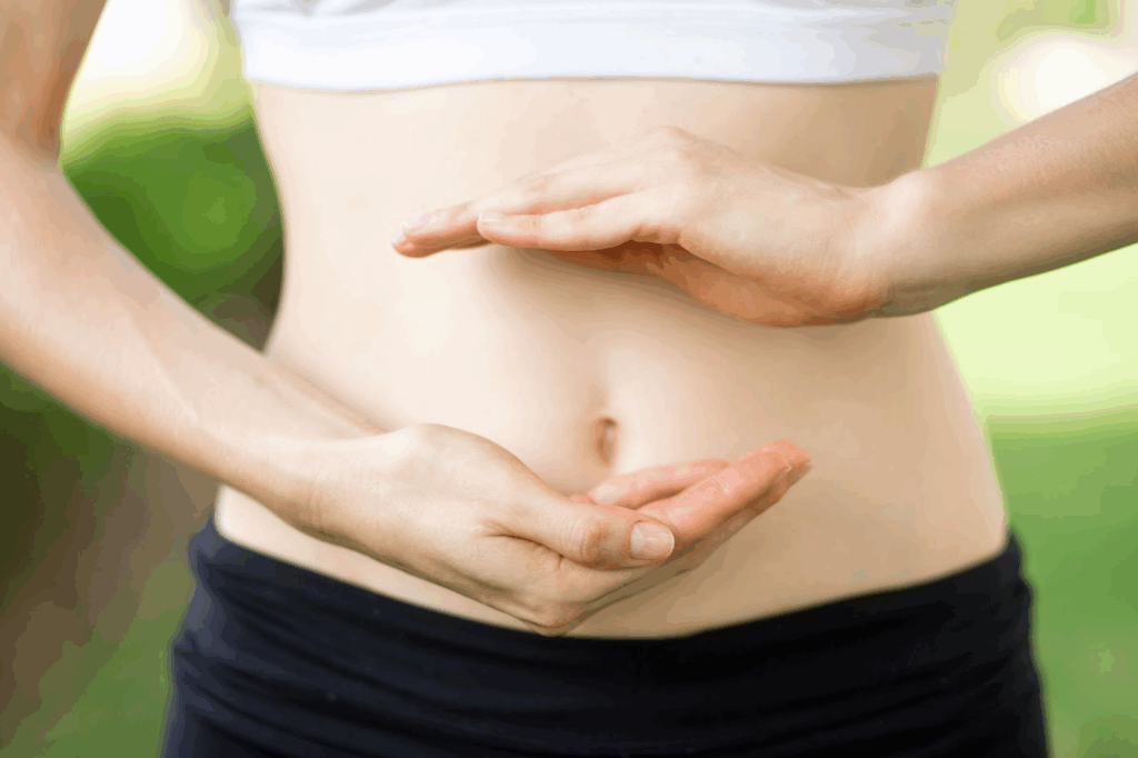 Aliments Anti-Stress : Votre Arme Naturelle Contre l'Anxiété au Quotidien Photo d'un ventre d'une femme qui place ses mains au dessus et en dessous de son nombril