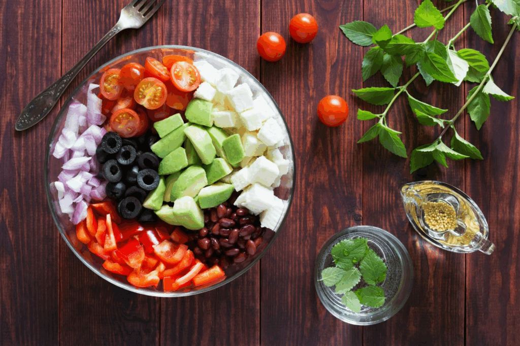 Aliments Anti-Stress : Votre Arme Naturelle Contre l'Anxiété au Quotidien Photo d'un saladier qui contient avocats, tomates, olives, poivrons et oignons.