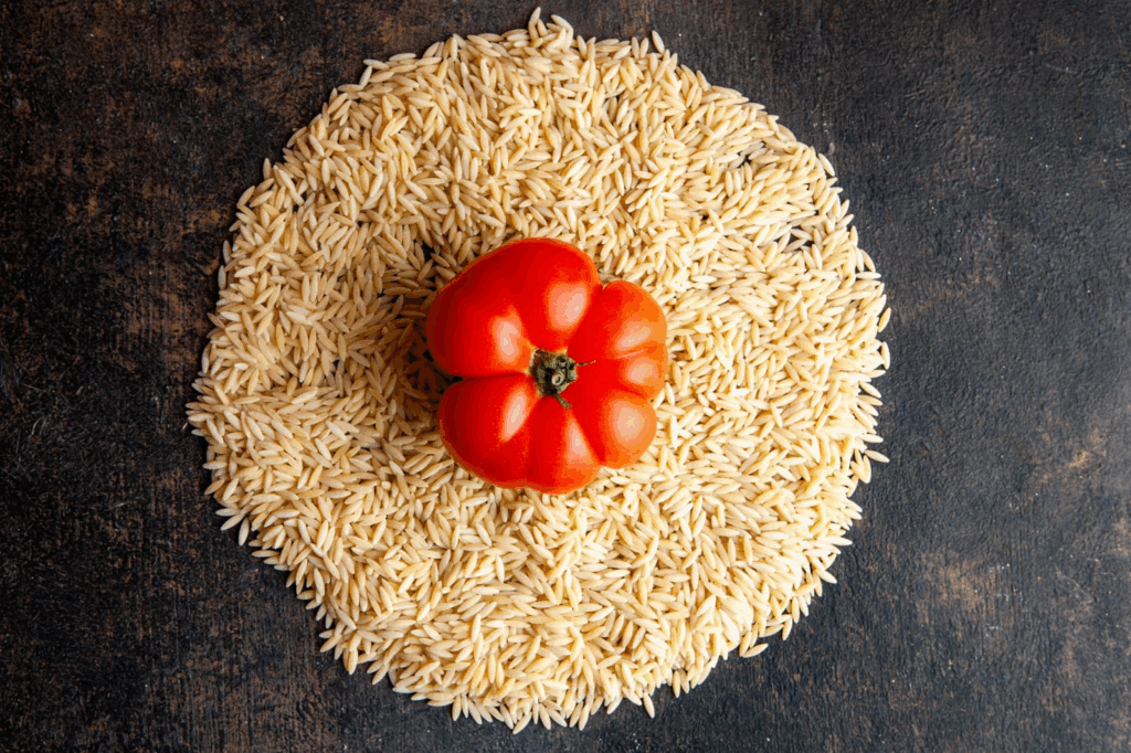 Aliments Anti-Stress : Votre Arme Naturelle Contre l'Anxiété au Quotidien Photo de grains de riz sur une table avec une tomate posée par dessus